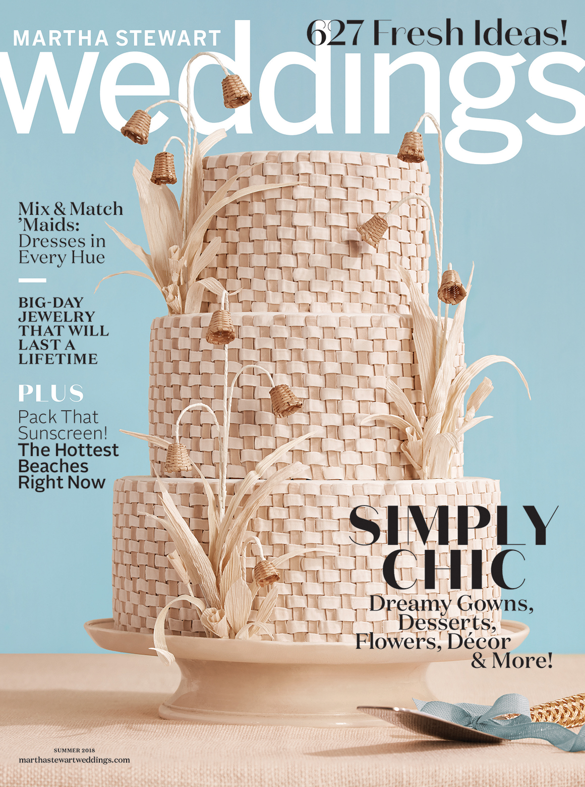 Martha Steward Weddings Magazine from summer 2018 titled "Simply Chic! Dreamy gowns, Desserts, Flowers, Decor, and more!" The cover features a three tiered wedding cake thats woven from a light wood straw material with tiny basket flowers and straw leaves on a blue background.